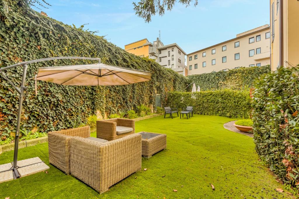 Giardino con divani in vimini e ombrellone