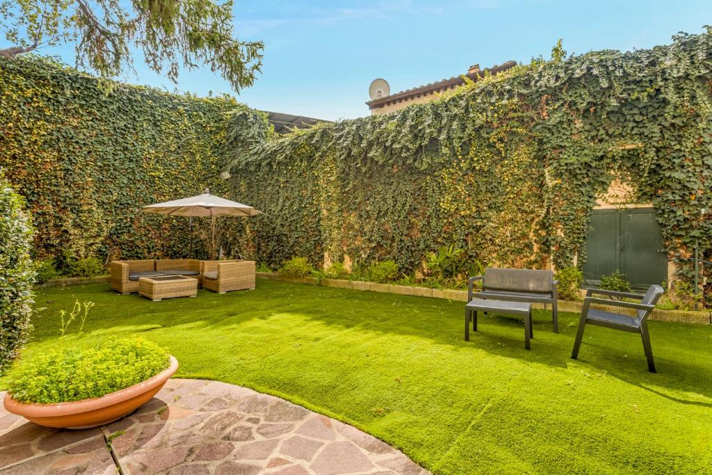 Giardino con prato, sedute e vegetazione